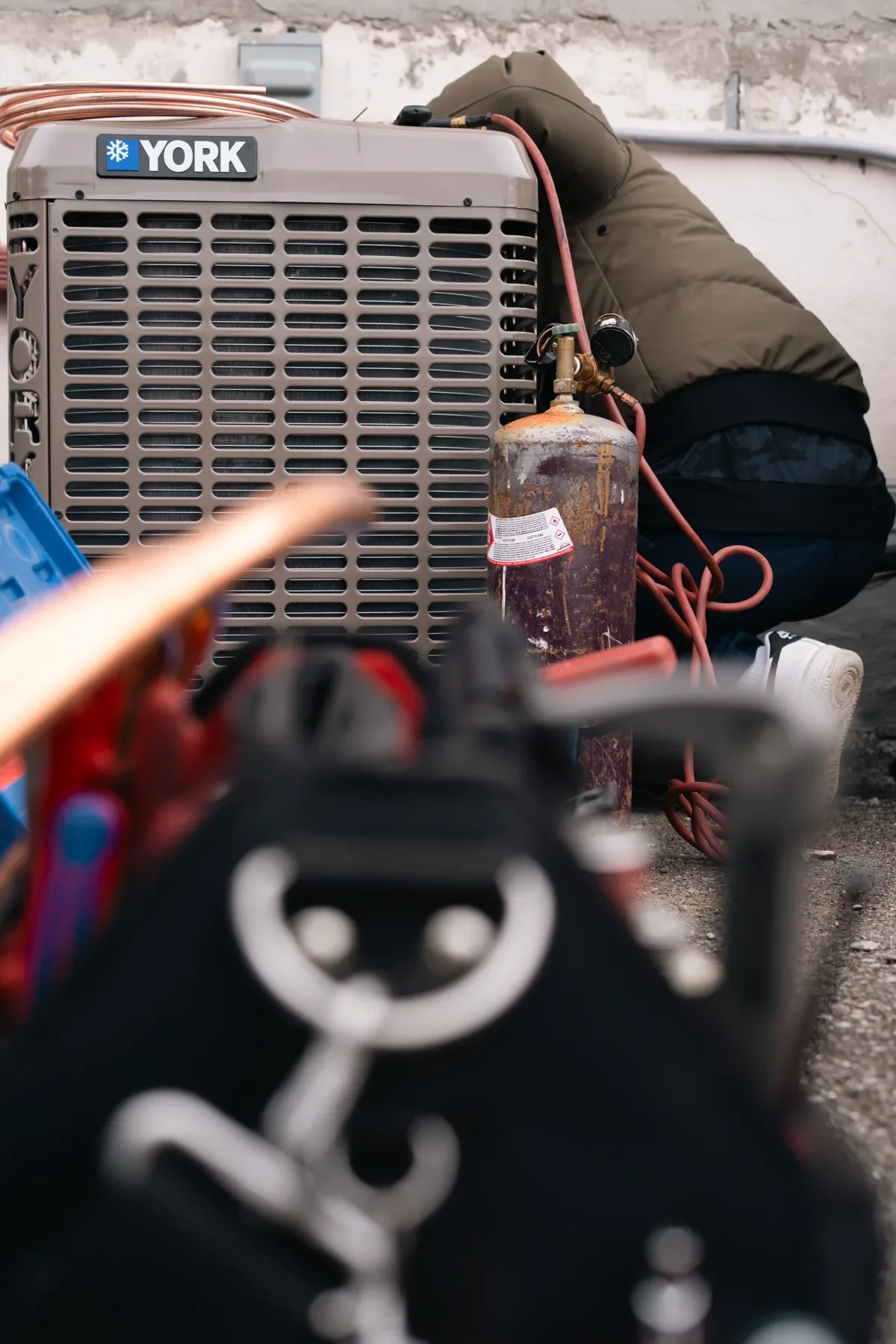 Technician diagnosing a residential outdoor air-conditioning unit