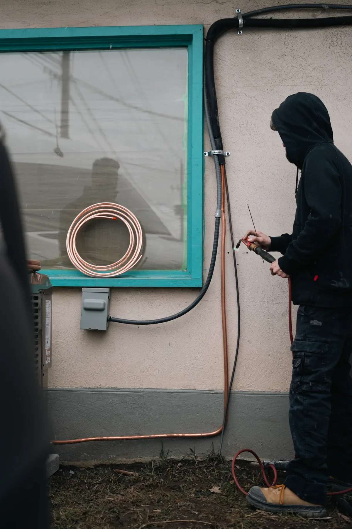Technician servicing outdoor air-conditioning piping and connections