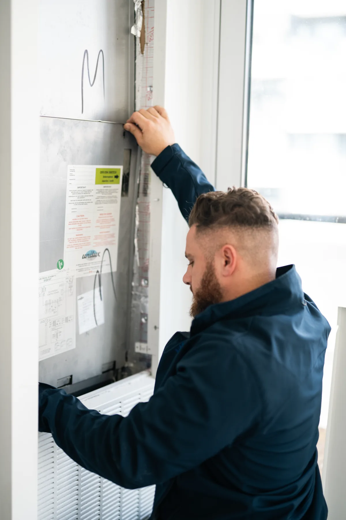 Technician reviewing a high-rise heat-pump unit service panel